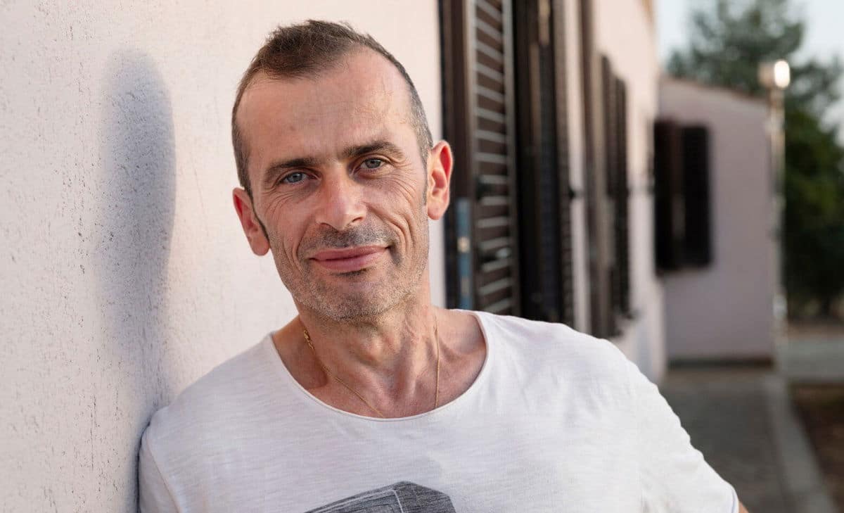 Portretfoto van Andrea, staand buiten zijn huis. Andrea leeft met MS en had graag iets meer willen weten over wat hij kon verwachten van de bijbehorende blaasklachten en darmproblemen. 