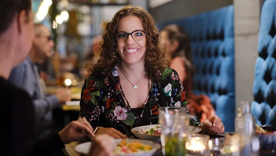 Foto van Marianne die uit eten is met vrienden. Marianne heeft een fijn netwerk van vrienden dat haar steunt. 