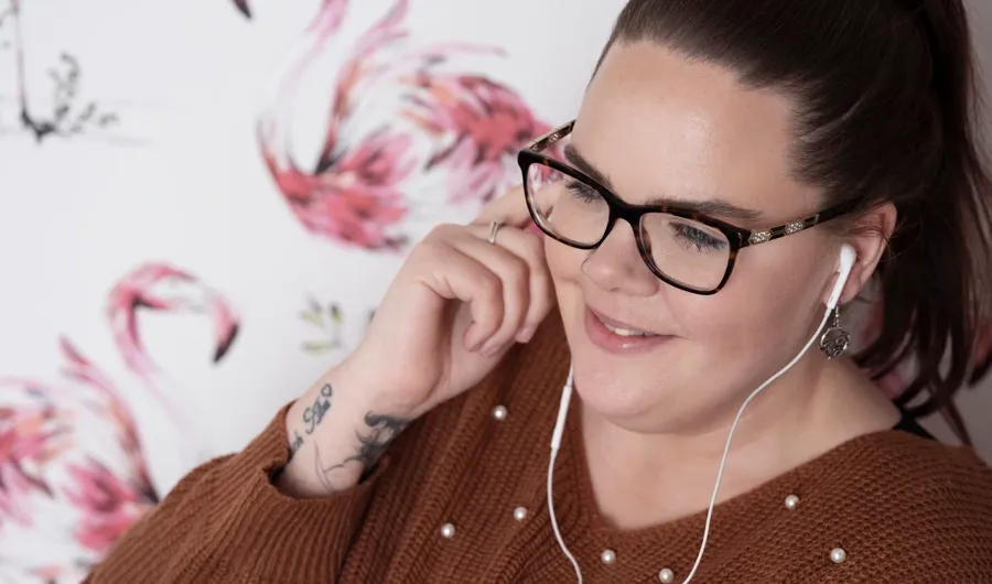 Portretfoto van Sarah, luisterend naar muziek. Sarah kreeg de diagnose MS en gebruikt katheters om haar blaasklachten te behandelen. 